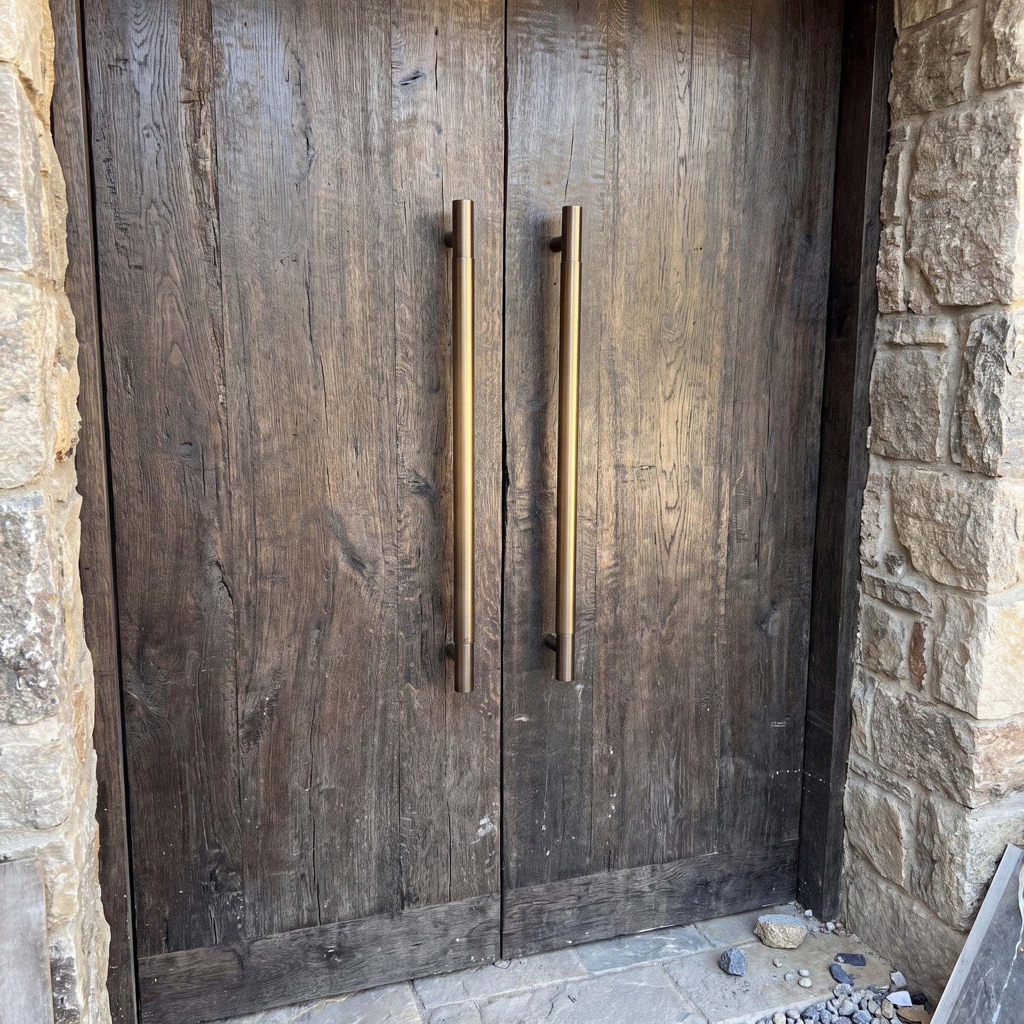 Round Tubular pull handles in brass on an entrance door