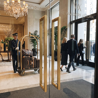 Cascade Bar pull handles in brass on a glass hotel entrance