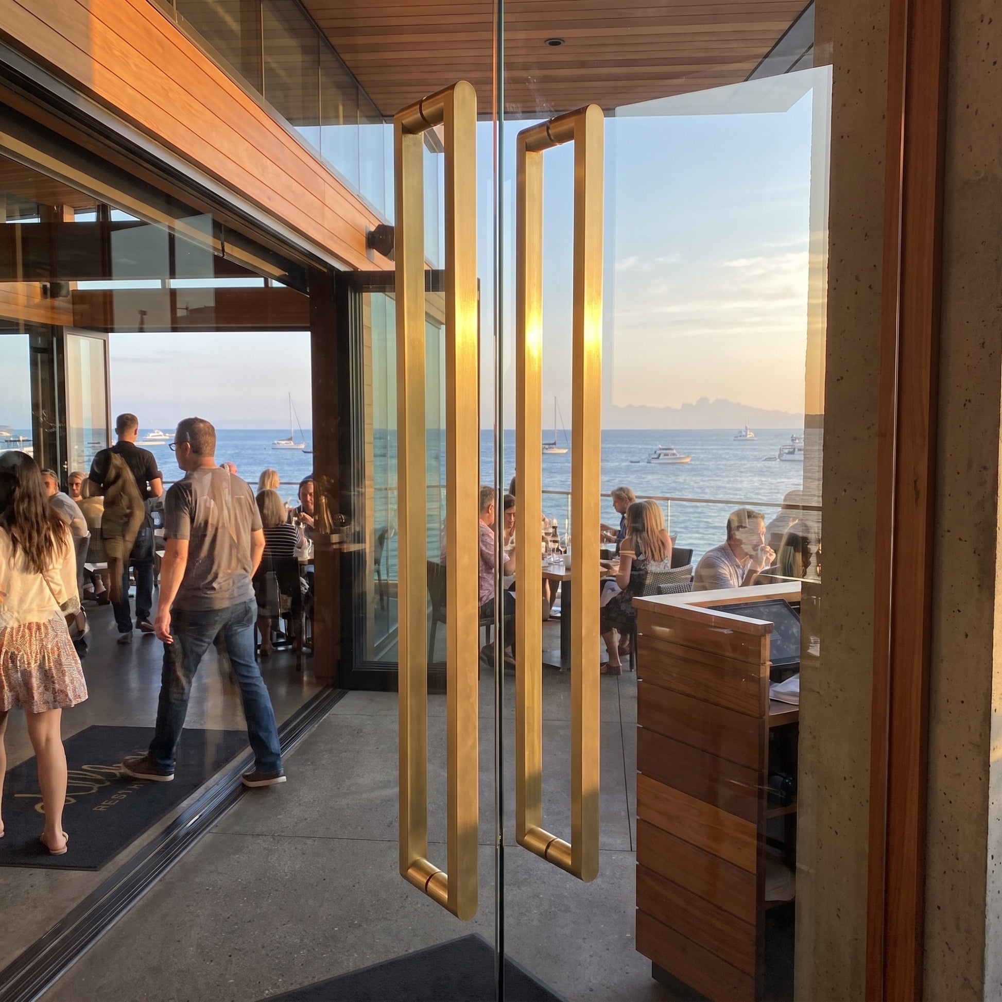 Cascade Bar pull handles in brass on a coastal restaurant entrance