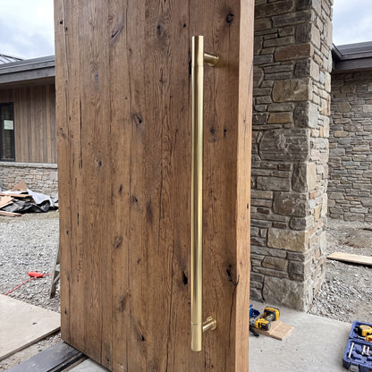 Round Tubular pull handle in brass on a timber door