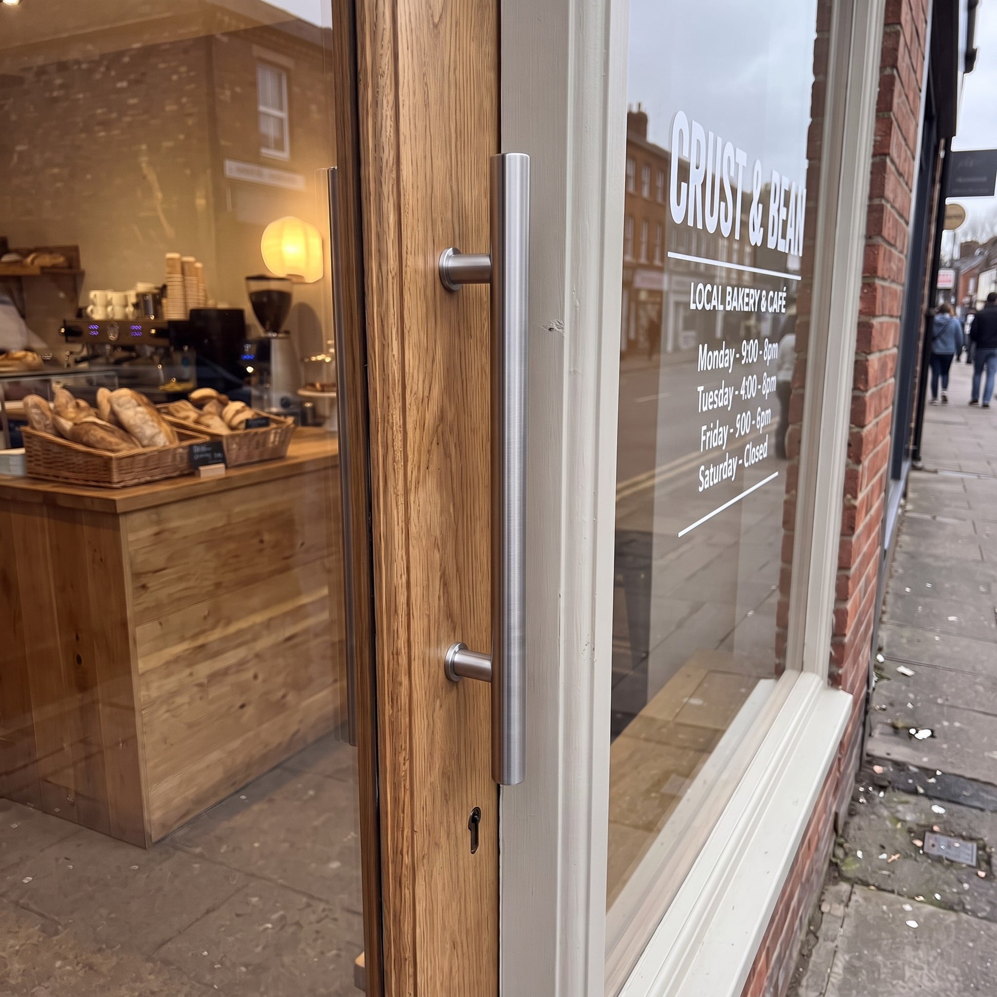 Round Tubular pull handle in 316 stainless on a shop entrance