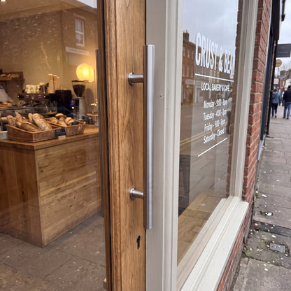 Round Tubular pull handle in 316 stainless on a shop entrance