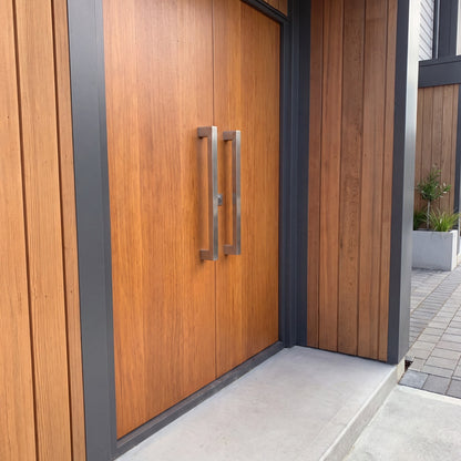 Straight Square Pull Handle 25mm in brushed 316 stainless, one handle on each leaf of a cedar double entrance door