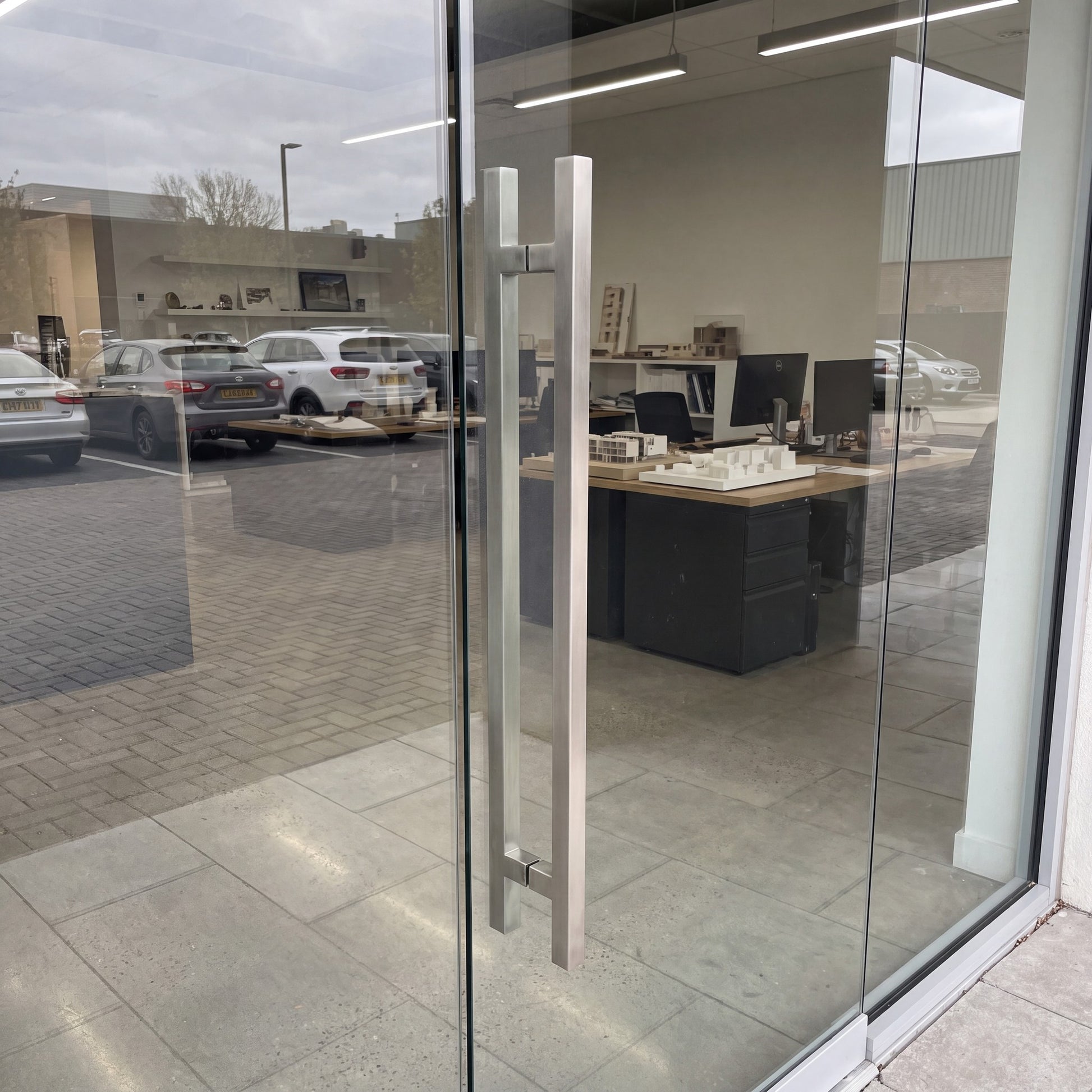Square T-Bar pull handles in 316 stainless on a glass door